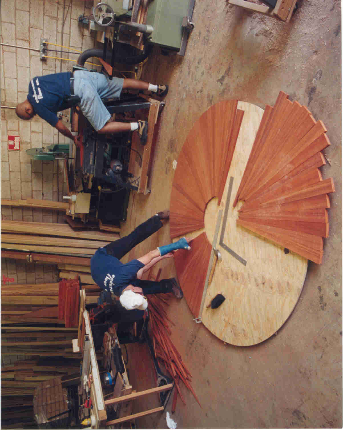 Endurance Floor Company craftspeople assembling a radial hardwood floor design in the West Park workshop