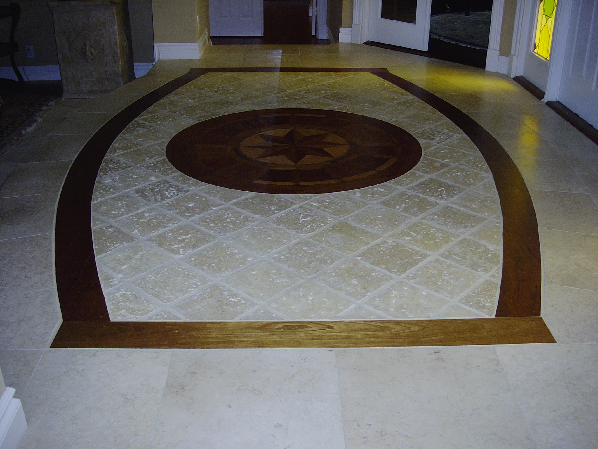Decorative hardwood border and medallion integrated with stone flooring