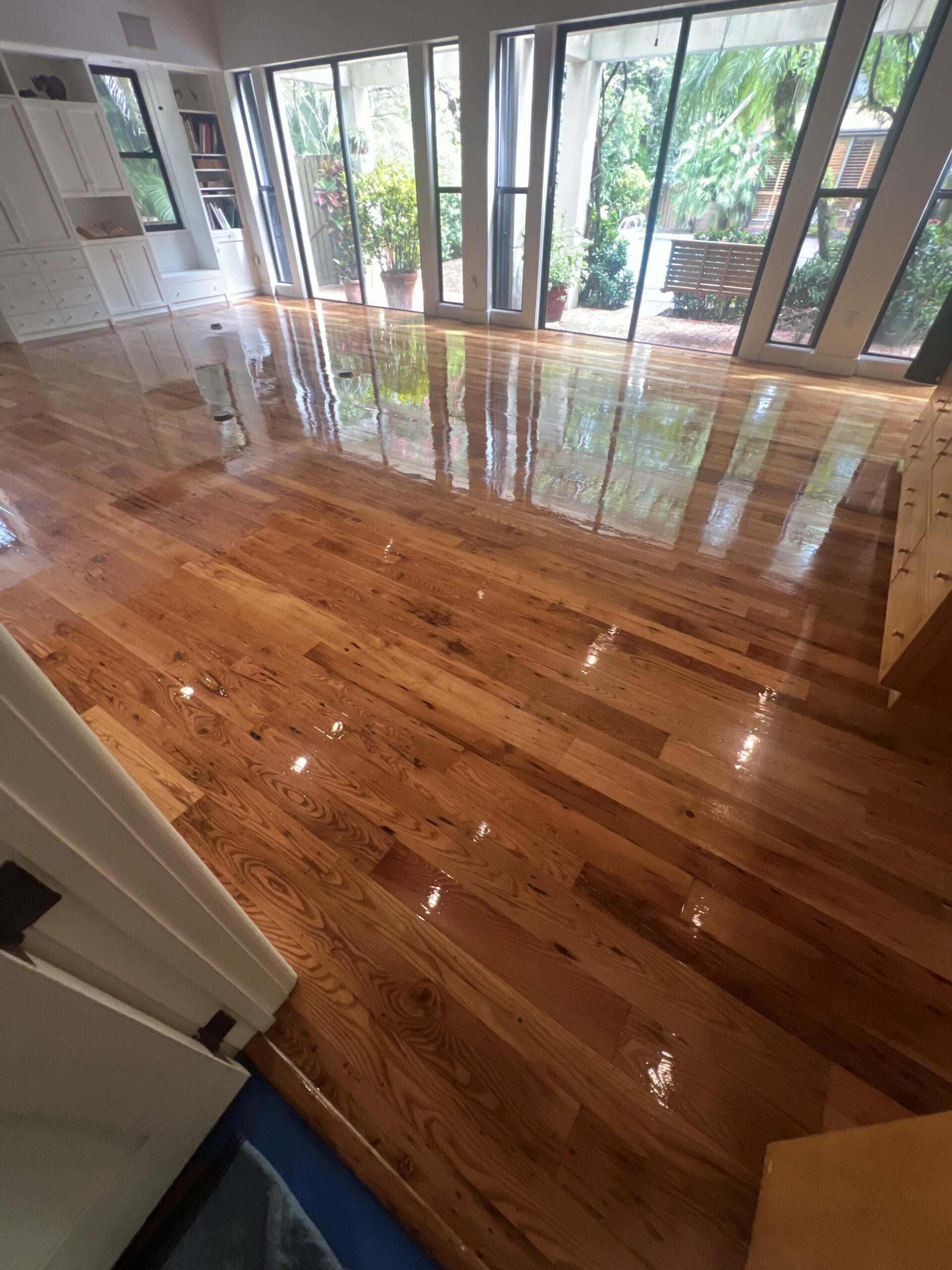 Finished hardwood floor in a bright South Florida interior with large architectural openings