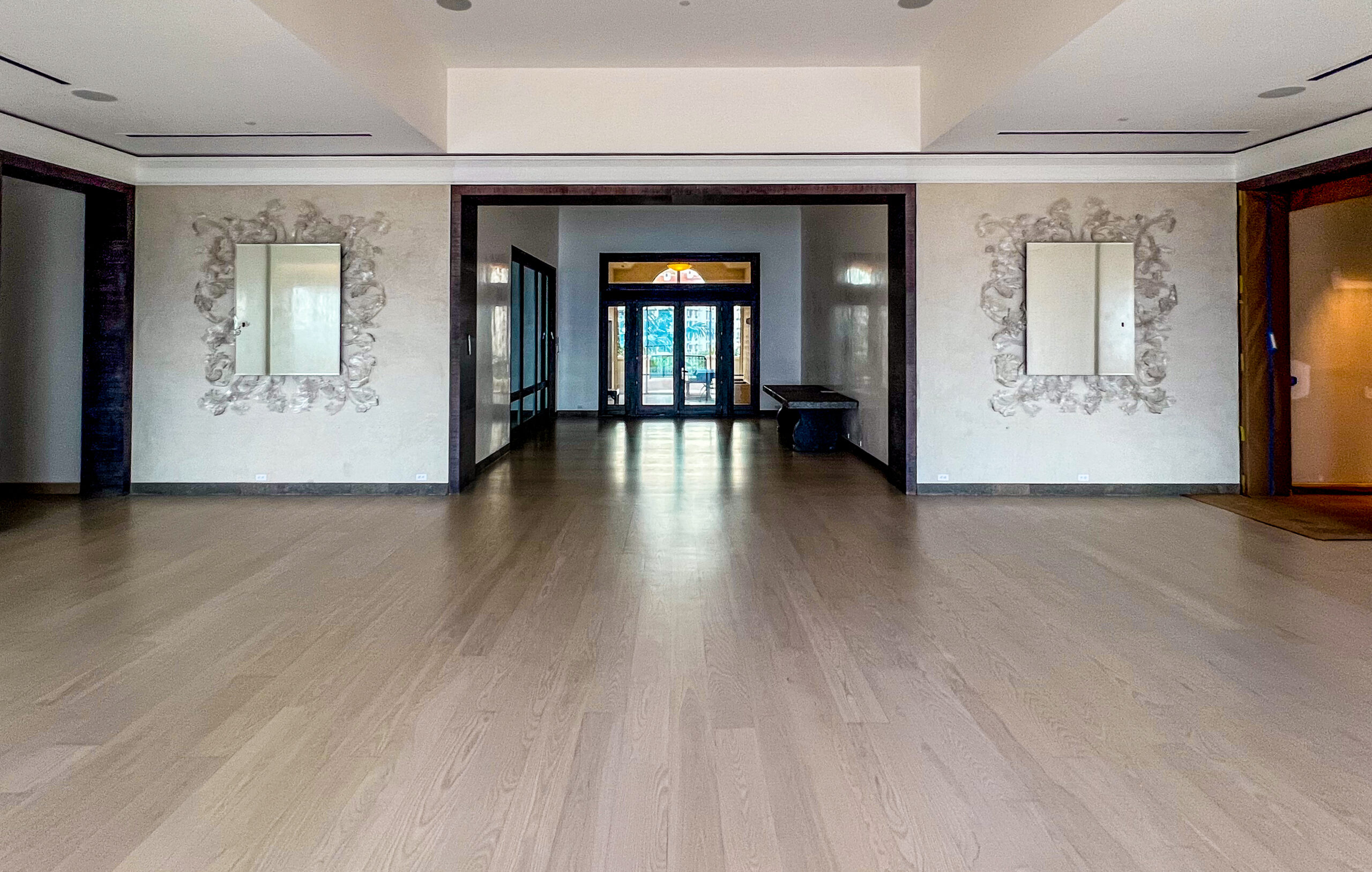 Finished hardwood floor in a bright South Florida interior with large architectural openings
